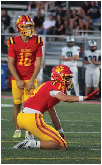Two football players wearing blue and white uniforms. Description generated by AI