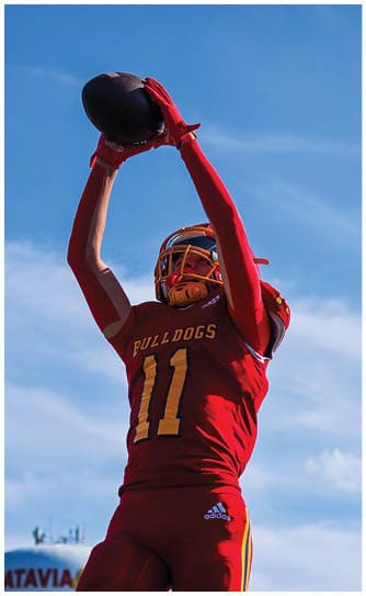 A football player catching a ball. Description generated by AI