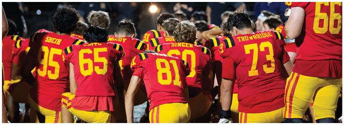 A group of football players on a field. Description generated by AI