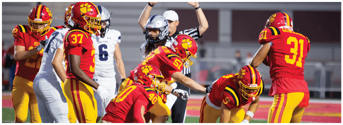 A group of football players on a field. Description generated by AI