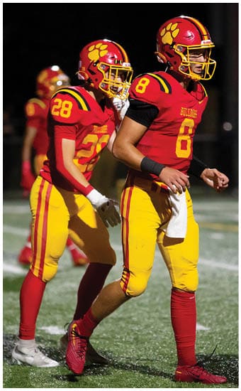 Two football players wearing blue and white uniforms. Description generated by AI