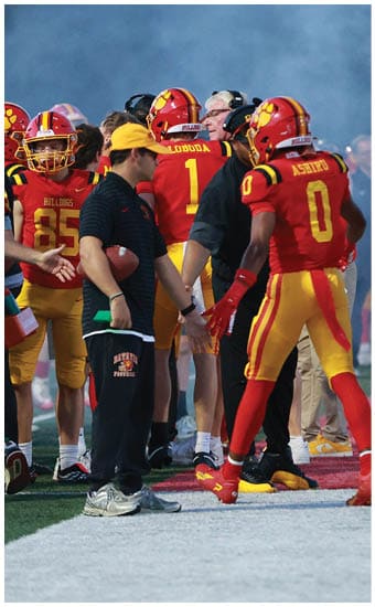 Two football players wearing blue and white uniforms. Description generated by AI