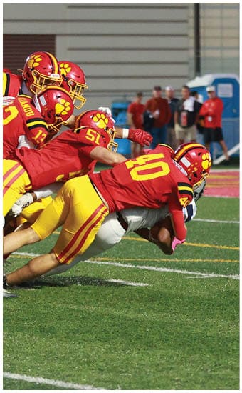 Two football players wearing blue and white uniforms. Description generated by AI
