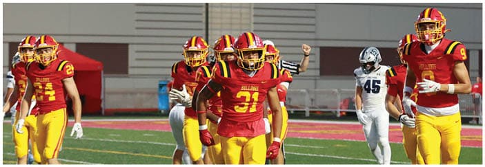 A football game is taking place on a field with players wearing blue and white uniforms. Description generated by AI