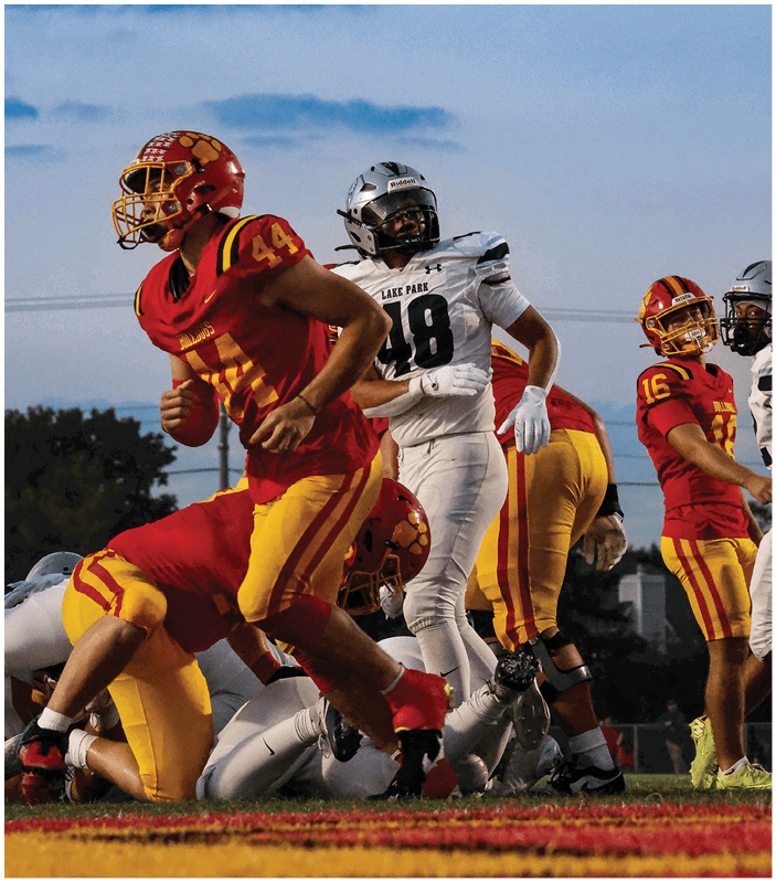 A group of football players on a field. Description generated by AI