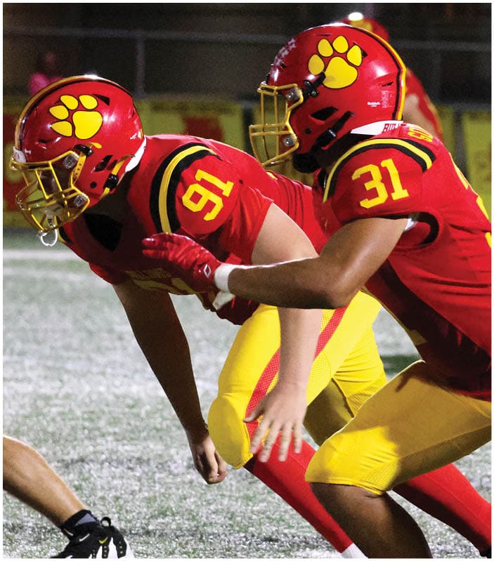 A group of football players on a field. Description generated by AI