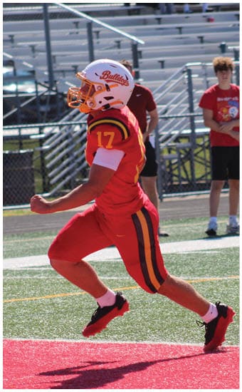 Two football players wearing blue and white uniforms. Description generated by AI
