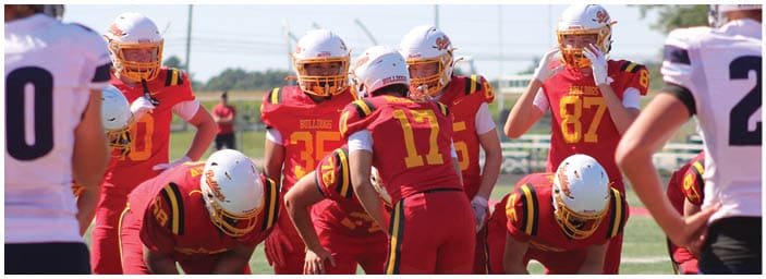 A group of football players on a field. Description generated by AI