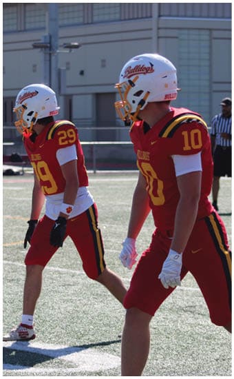 Two football players wearing blue and white uniforms. Description generated by AI