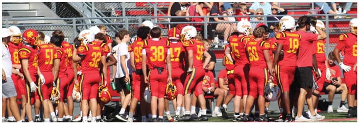 A football game is taking place on a field with players wearing blue and white uniforms. Description generated by AI