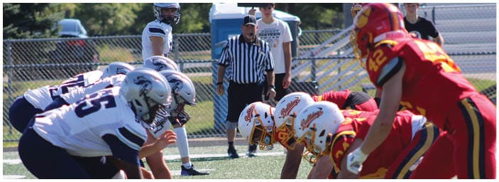 A group of football players on a field. Description generated by AI