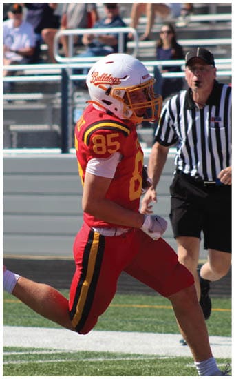 Two football players wearing blue and white uniforms. Description generated by AI