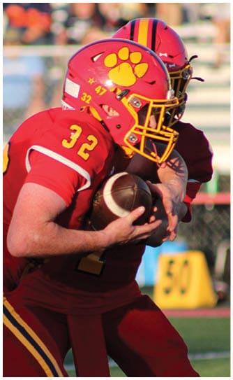 A football player catching a ball. Description generated by AI
