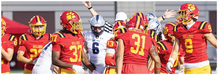 A football game is taking place on a field with players wearing blue and white uniforms. Description generated by AI
