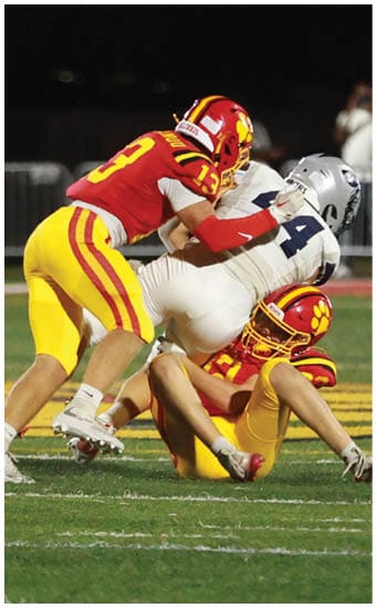 Two football players wearing blue and white uniforms. Description generated by AI