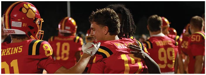A group of football players on a field. Description generated by AI