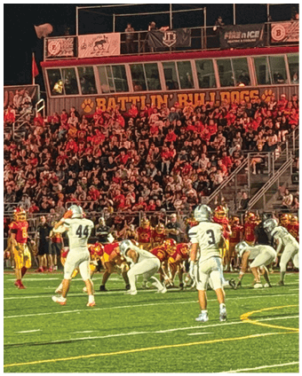 Two football players wearing blue and white uniforms. Description generated by AI