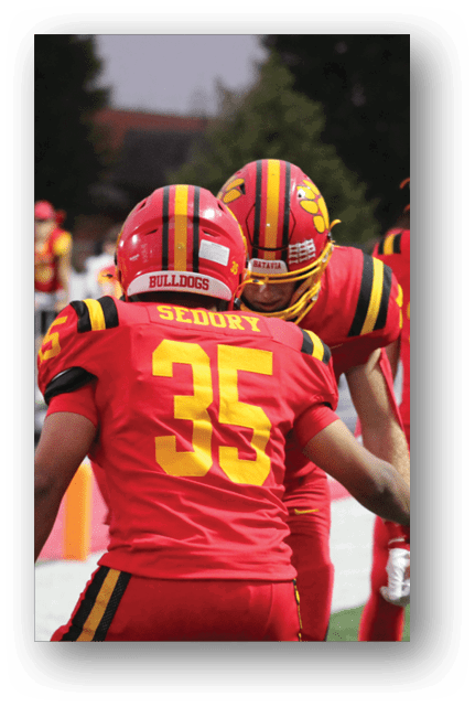 Two football players wearing blue and white uniforms. Description generated by AI