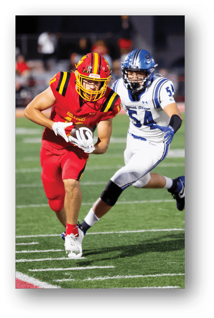 Two football players wearing blue and white uniforms. Description generated by AI
