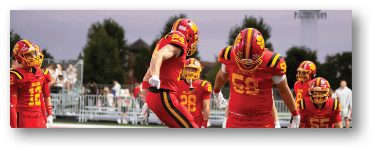 A football game is taking place on a field with players wearing blue and white uniforms. Description generated by AI