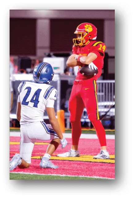 Two football players wearing blue and white uniforms. Description generated by AI