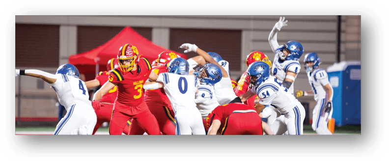 A football game is taking place on a field with players wearing blue and white uniforms. Description generated by AI