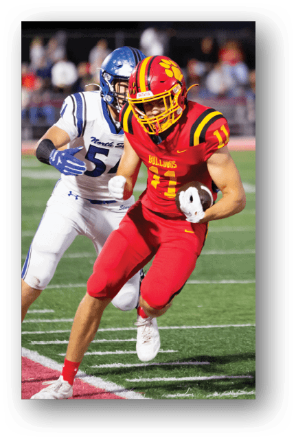Two football players wearing blue and white uniforms. Description generated by AI