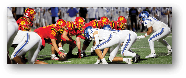 A football game is taking place on a field with players wearing blue and white uniforms. Description generated by AI