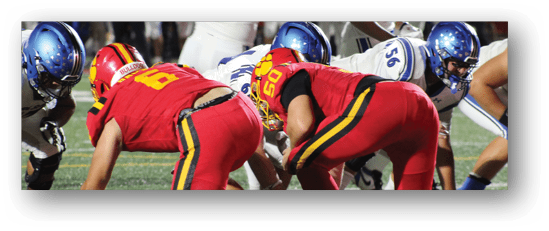 A football game is taking place on a field with players wearing blue and white uniforms. Description generated by AI