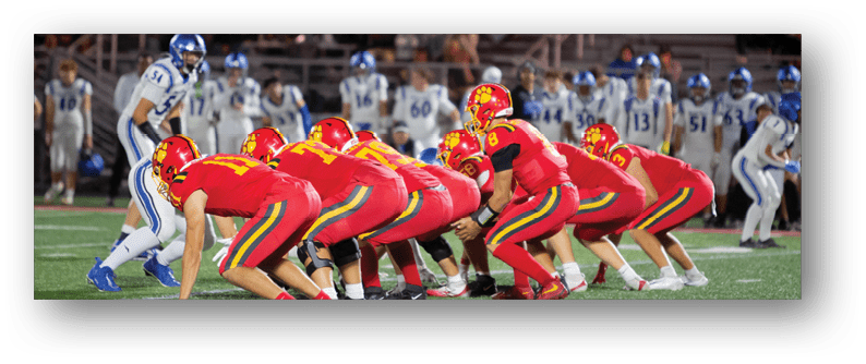 A football game is taking place on a field with players wearing blue and white uniforms. Description generated by AI