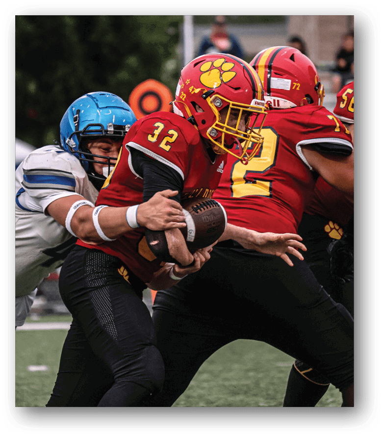 Three football players in blue and white uniforms running on a field. Description generated by AI