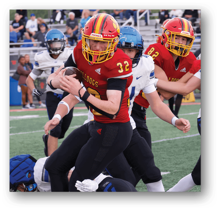 Three football players in blue and white uniforms running on a field. Description generated by AI