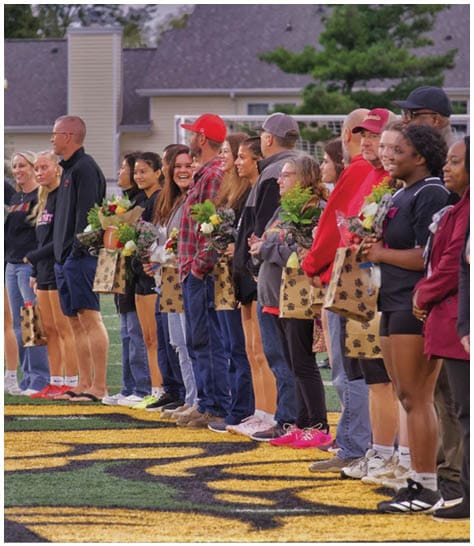 Two football players wearing blue and white uniforms. Description generated by AI