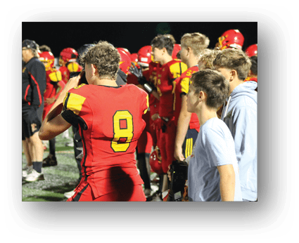 A group of football players on a field. Description generated by AI