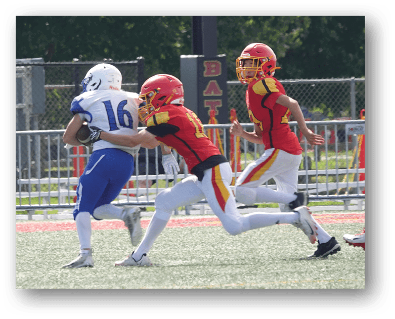 Three football players in blue and white uniforms running on a field. Description generated by AI