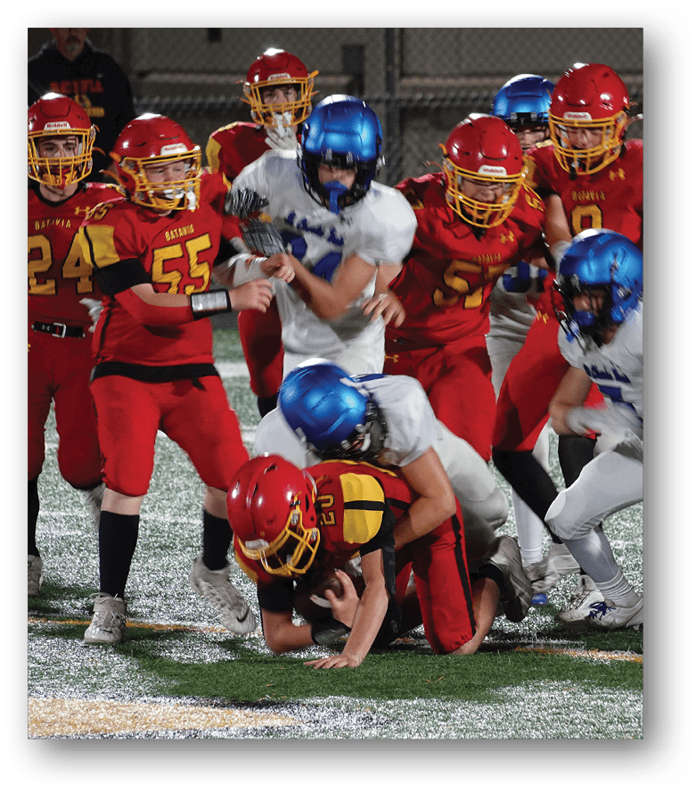 Three football players in blue and white uniforms running on a field. Description generated by AI