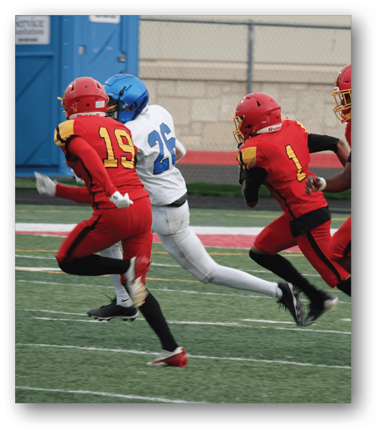Three football players in blue and white uniforms running on a field. Description generated by AI