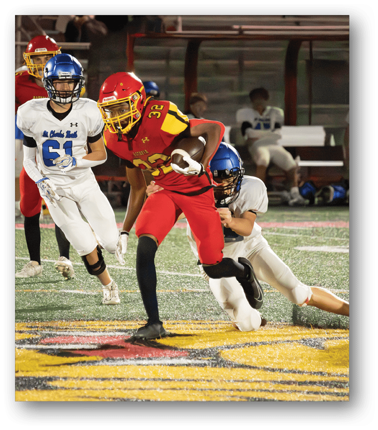 Three football players in blue and white uniforms running on a field. Description generated by AI