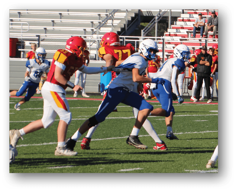 Three football players in blue and white uniforms running on a field. Description generated by AI