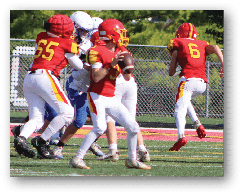 Three football players in blue and white uniforms running on a field. Description generated by AI