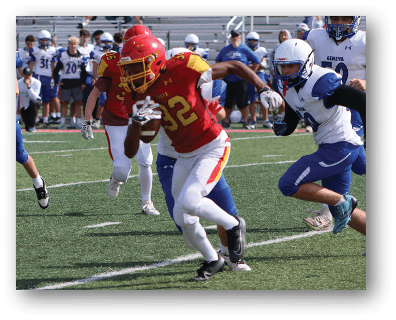 Three football players in blue and white uniforms running on a field. Description generated by AI