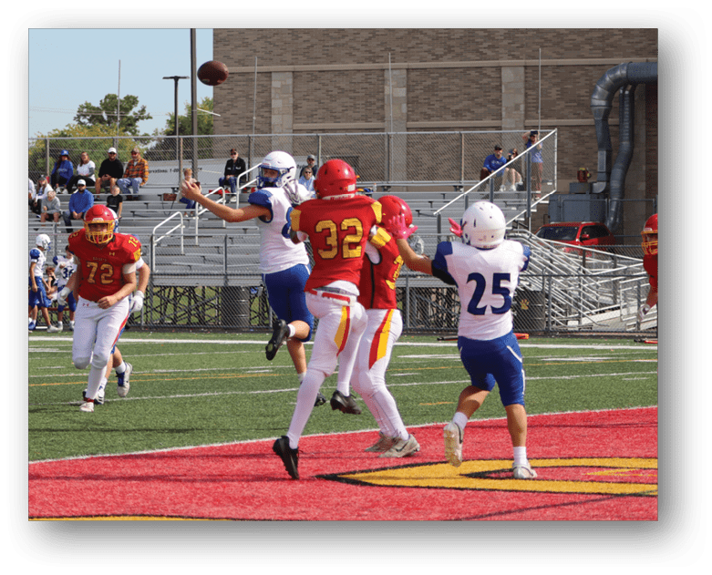 Three football players in blue and white uniforms running on a field. Description generated by AI
