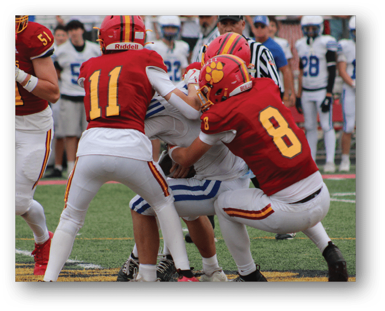 Three football players in blue and white uniforms running on a field. Description generated by AI