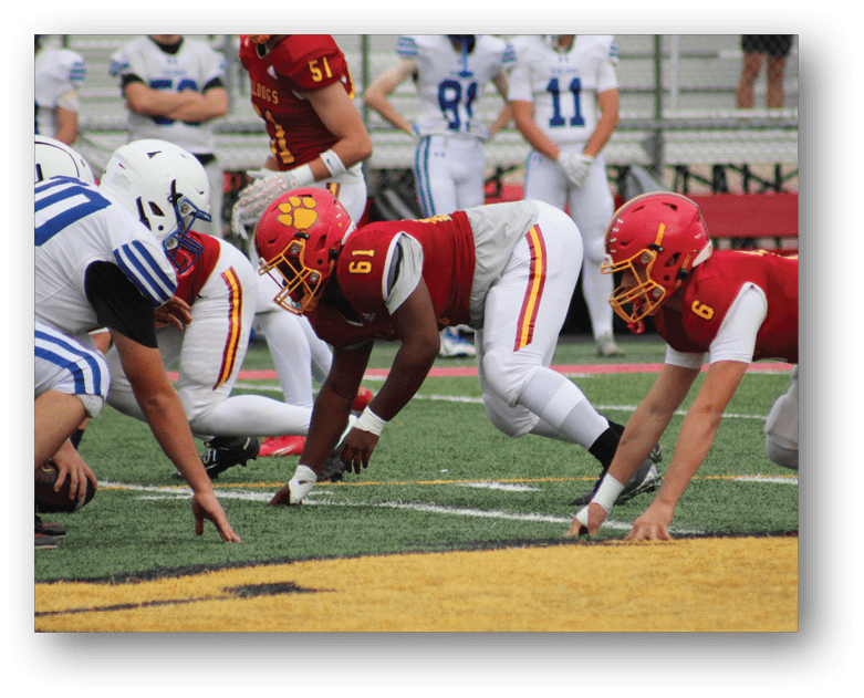Three football players in blue and white uniforms running on a field. Description generated by AI