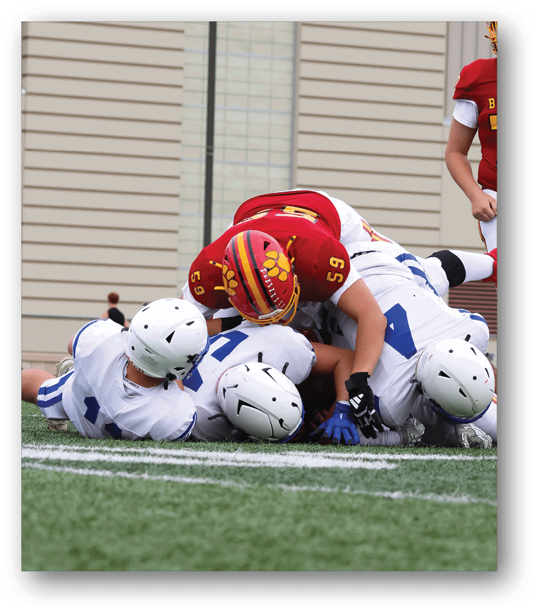 Three football players in blue and white uniforms running on a field. Description generated by AI