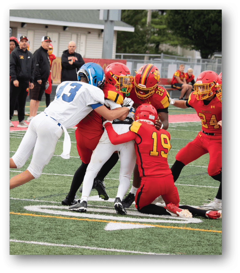 Three football players in blue and white uniforms running on a field. Description generated by AI