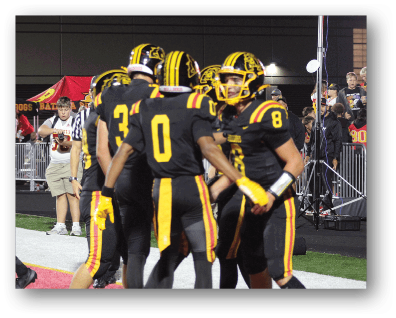 A group of football players on a field. Description generated by AI