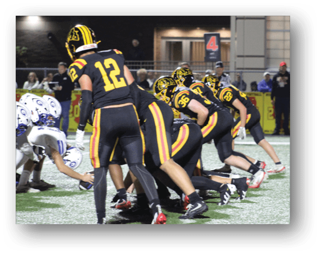 A football game is taking place on a field with players wearing blue and white uniforms. Description generated by AI