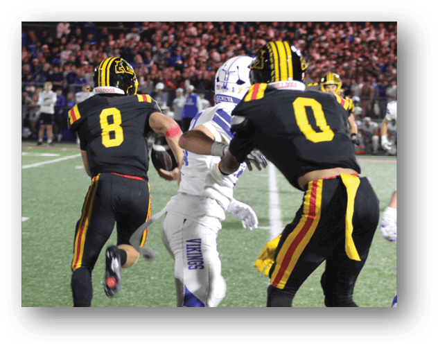 A football game is taking place on a field with players wearing blue and white uniforms. Description generated by AI