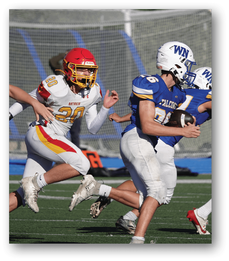 Three football players in blue and white uniforms running on a field. Description generated by AI